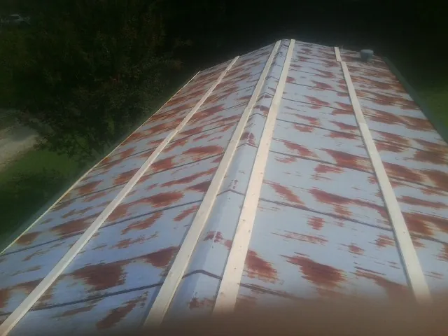 Rusted metal roof panels with new wood purlins before replacement — Storm Damage Roof Repair in Conesville by Roofing Brothers