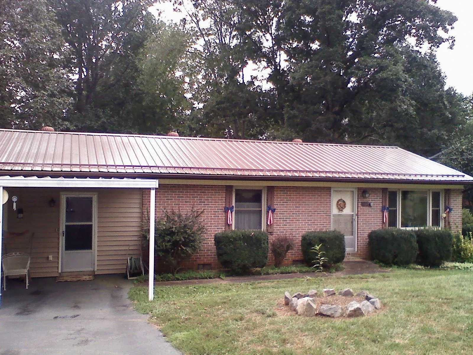 Bronze metal roof and carport on a brick ranch home — Roof Repair work by our crew in Conesville